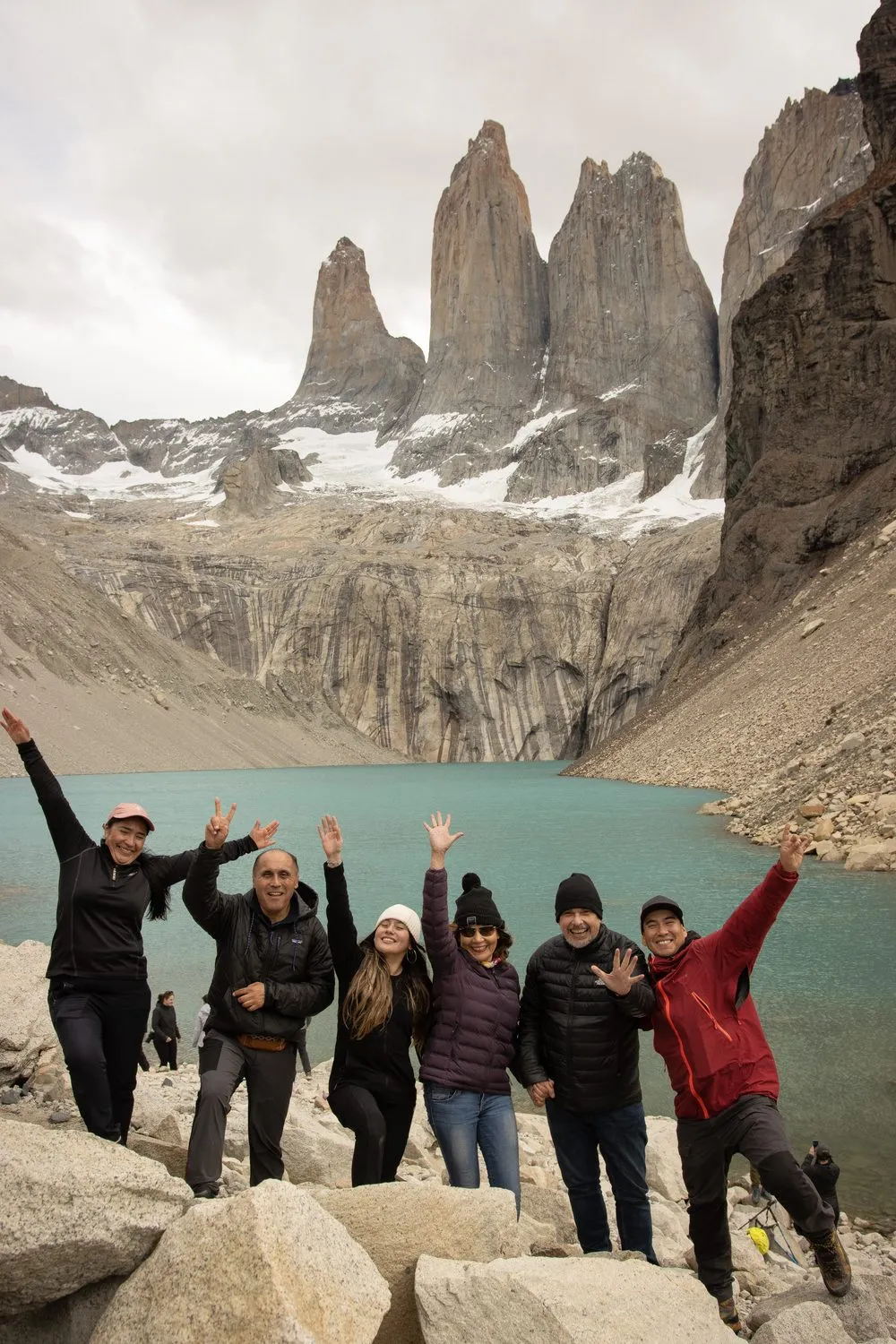 Grupo de viajeros celebrando frente a la laguna y las Torres del Paine